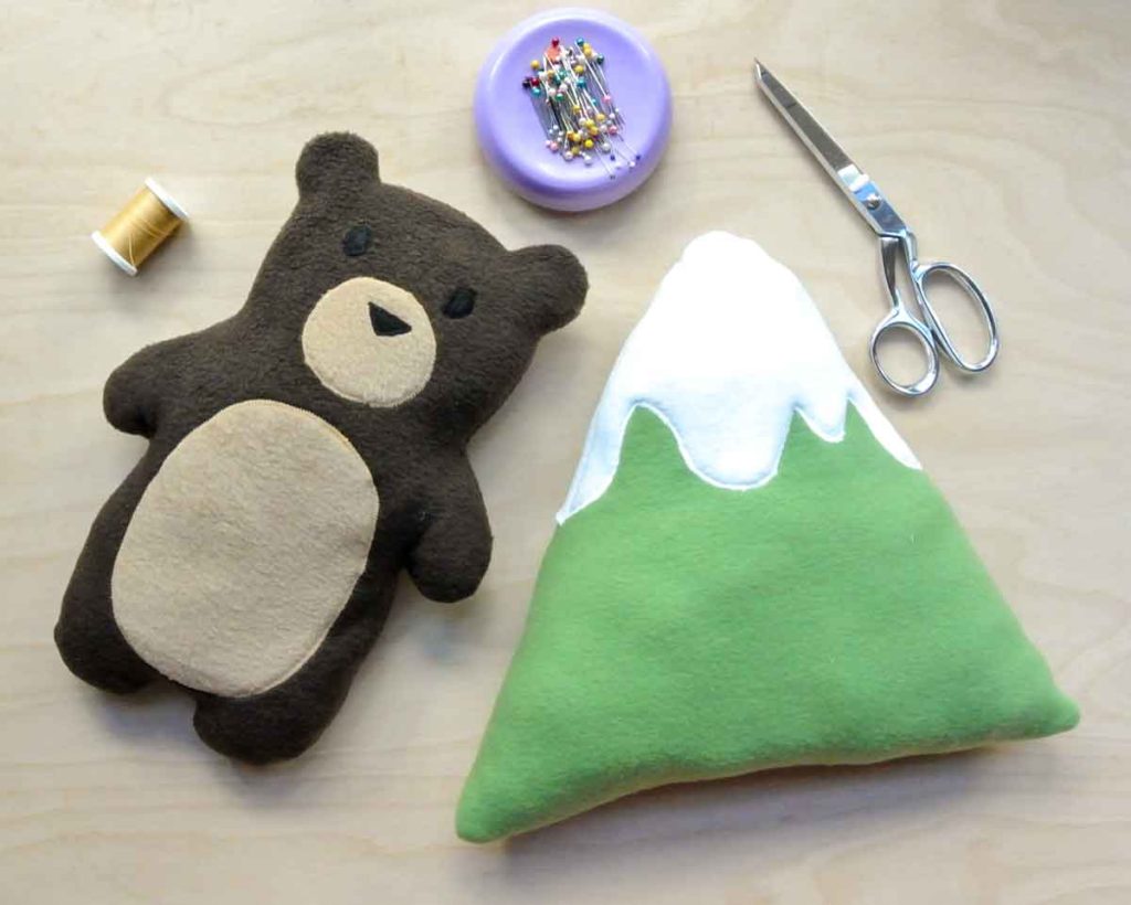 Shows Finished DIY Bear and Mountain Plushie with scissors, pins, and thread. How to Make a Plushie Tutorial