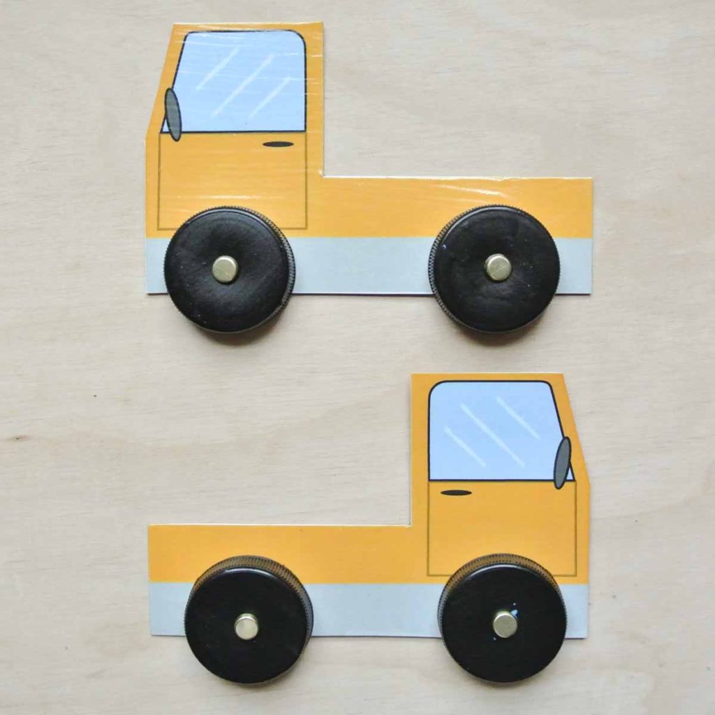 Plastic wheels placed on sides of cardboard toy truck. How to make DIY Tow Truck Toy