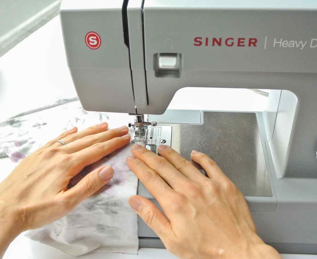 How to sew Knit fabric using hands to gently guide fabric into machine as you sew