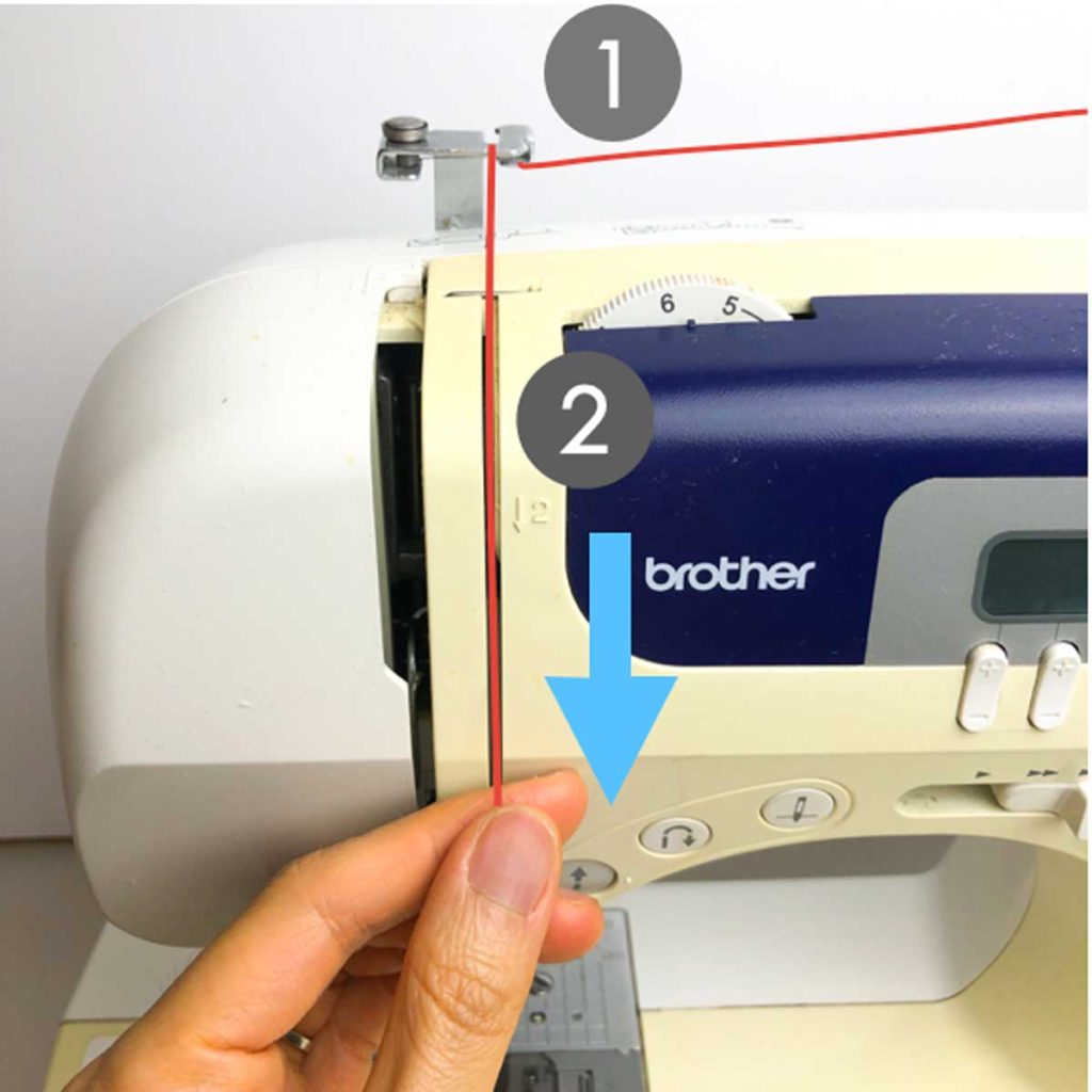 How to thread a brother sewing machine. Shows left hand threading upper thread through machine following arrows and numbers on brother sewing machine.