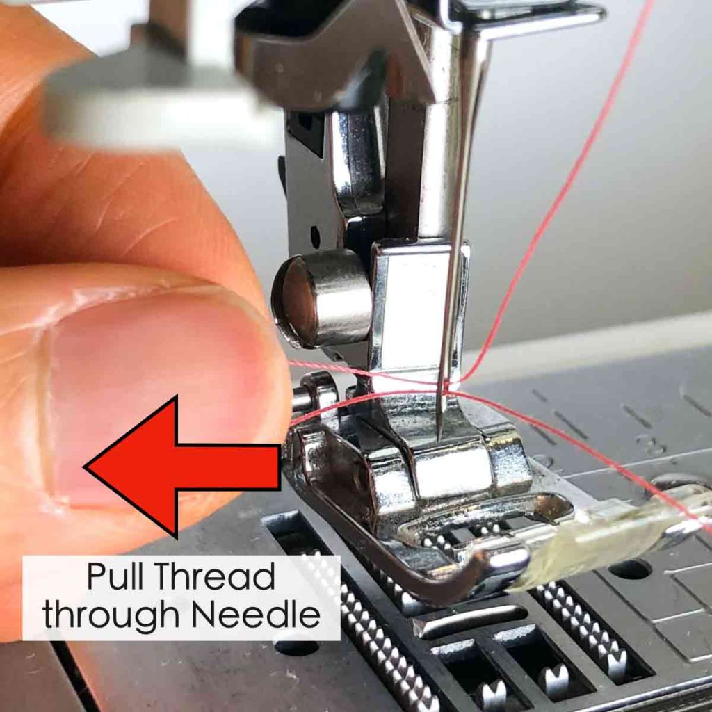 How to use built-in needle threader. Shows left hand pulling thread through eye of needle