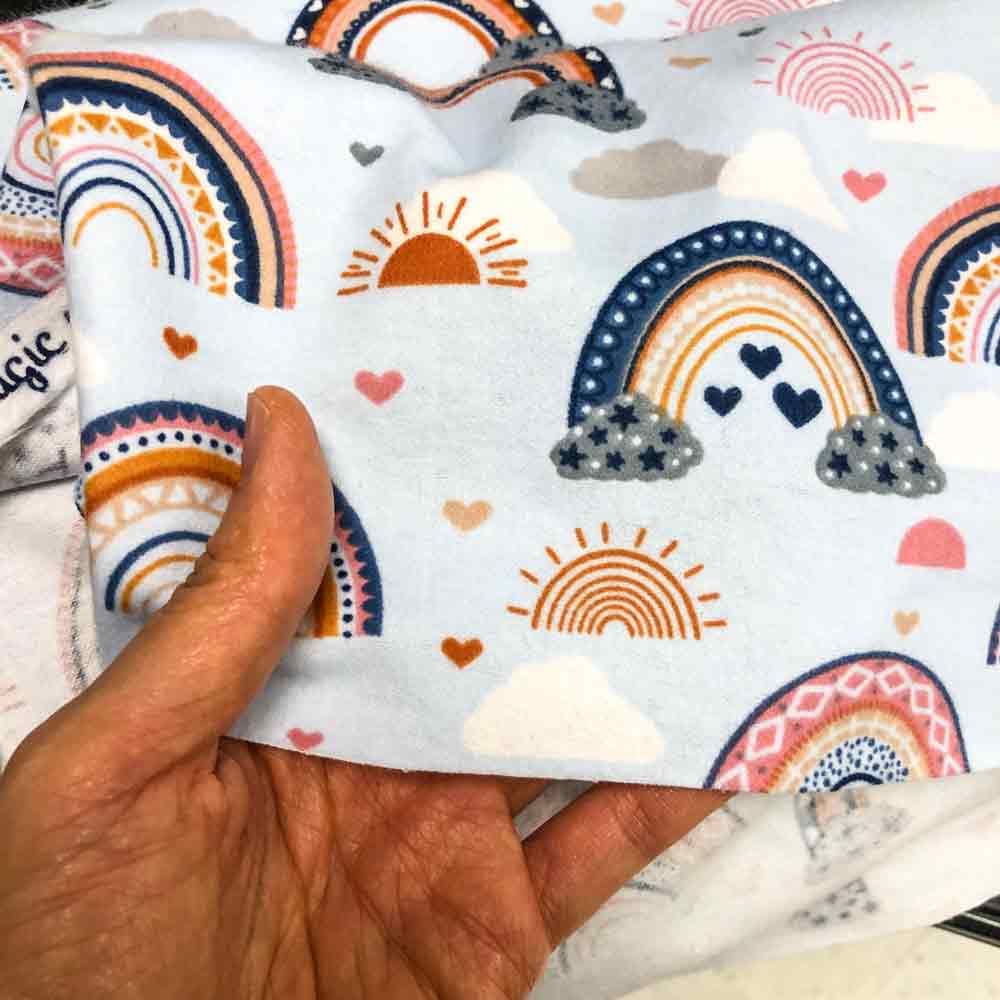 what fabric is best for baby bibs. Hand holding 100% cotton flannel fabric up close image 