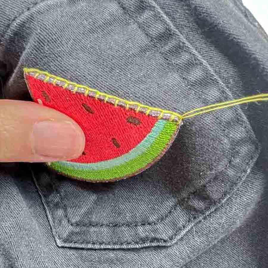 Row of blanket stitches around border of patch. 