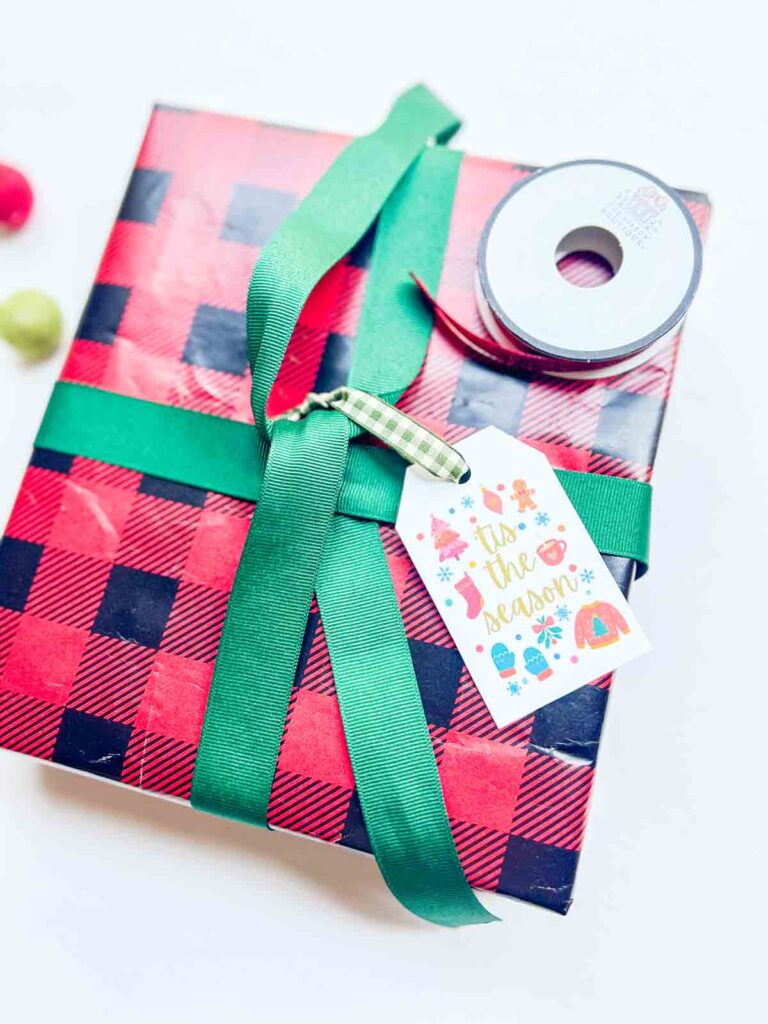 christmas tag attached to ribbon of christmas gift