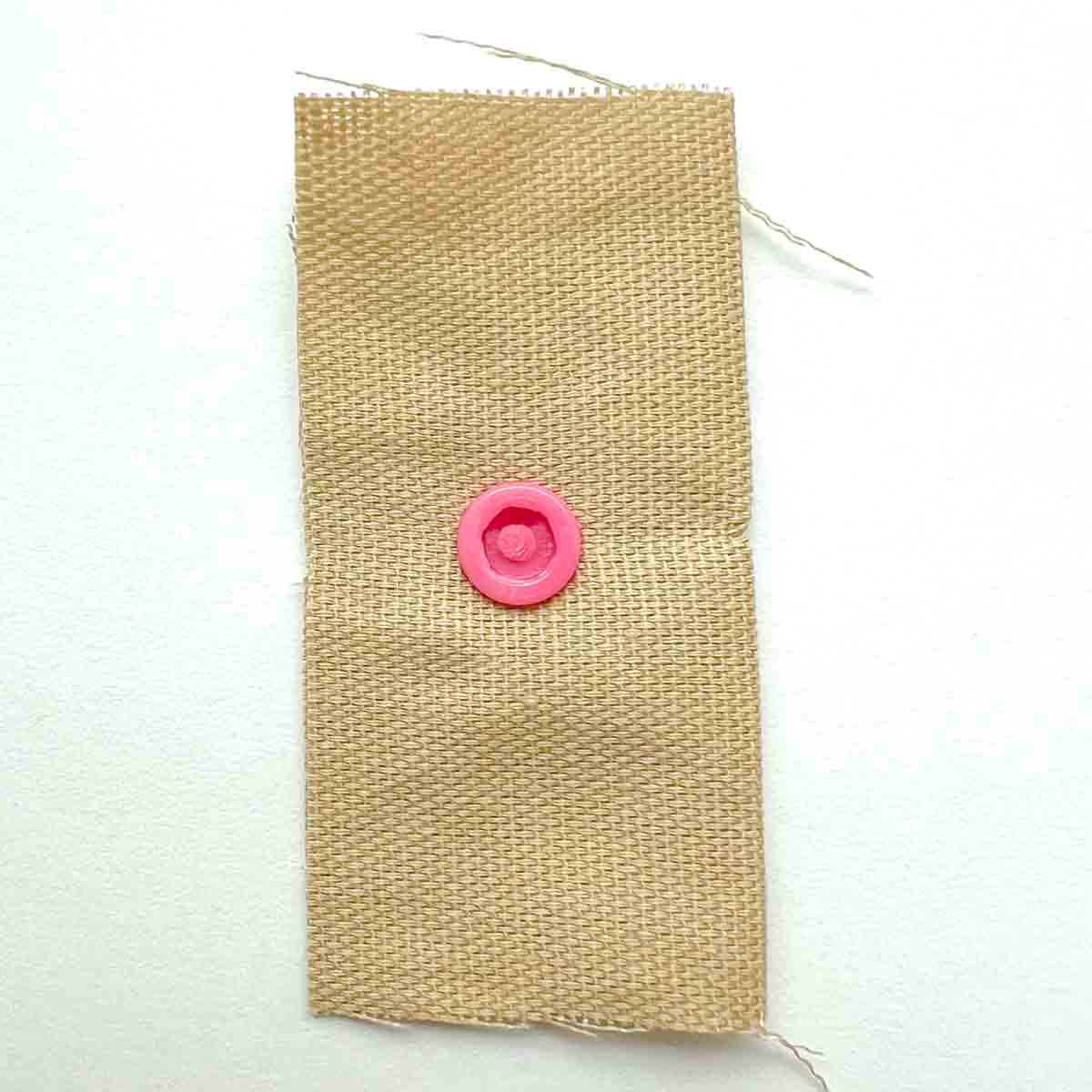 How to apply snaps to fabric using a snap press - view of snap socket correctly pressed into fabric. 