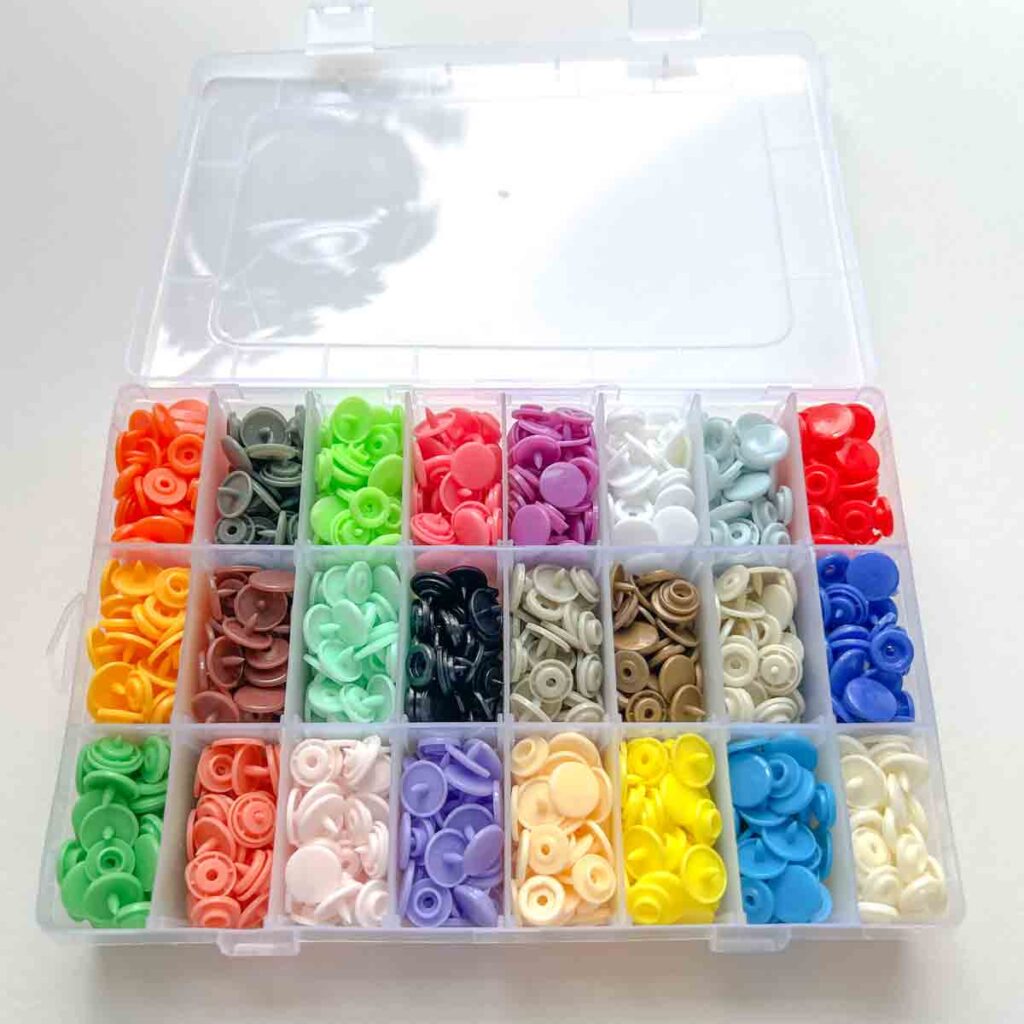 box of plastic snaps with a wide variety of colors