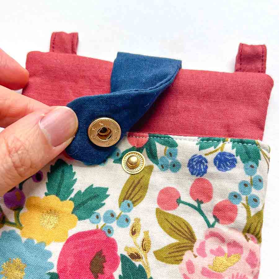 snaps added to flap of crossbody phone bag
