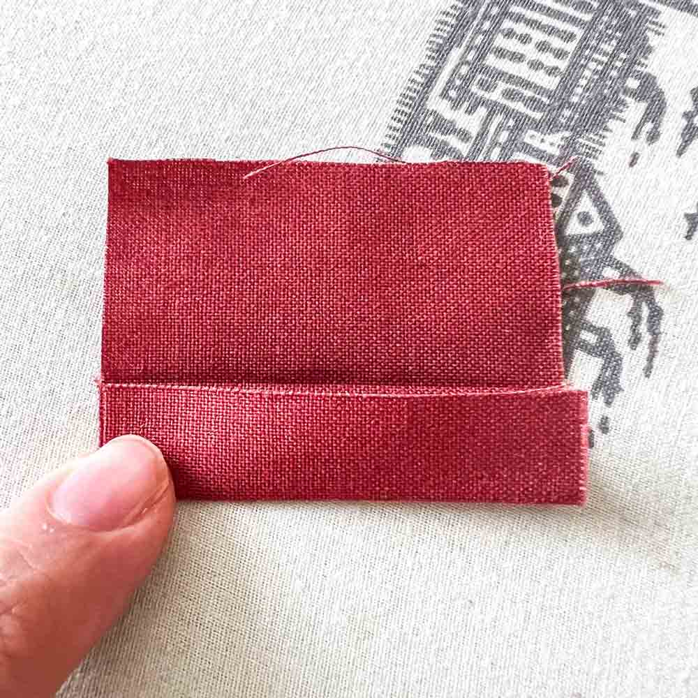 making loops for bag straps. folding bottom edge of loops piece to midline