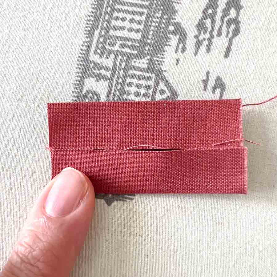 folding top edge of loops piece to midline
