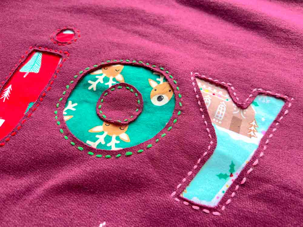 Finished burgundy sweatshirt with a colorful reverse appliqué design